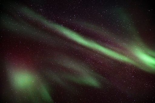 A mesmerizing view of Aurora Borealis in the starry sky in Kvaloya, Arctic region in Norway