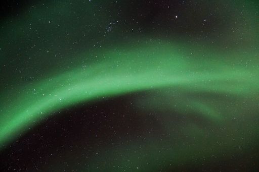 A night starry sky with Aurora Borealis beautiful green lights in Kvaloya, Arctic region, Norway