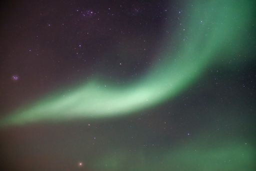 A night starry sky with breathtaking Aurora Borealis lights in Kvaloya, Arctic region, Norway