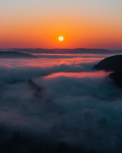 A vertical shot of a fascinating sunrise with clouds bellow