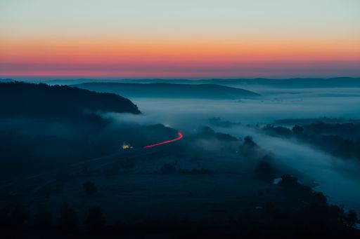 A landscape with a fascinating sunrise and mountains in the fog