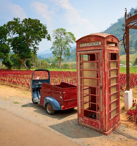 A vertical shot of an old phone booth in the countryside in Thailand