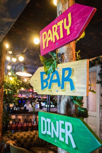 A vertical shot of different colored signs with a blurred background