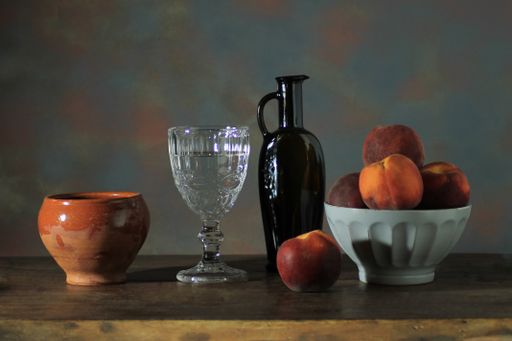 A Closeup of a bowl of peach and drinks  on a wooden table on a dark background