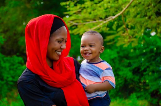 A smiling African mother with her child in a park