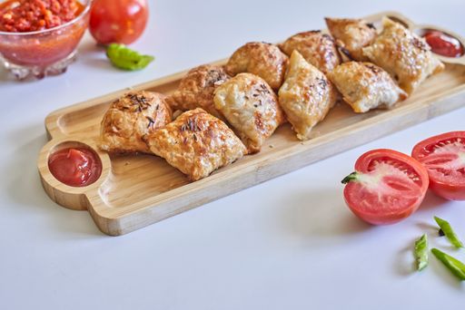 The homemade pies with tomato sauce on a wooden serving board
