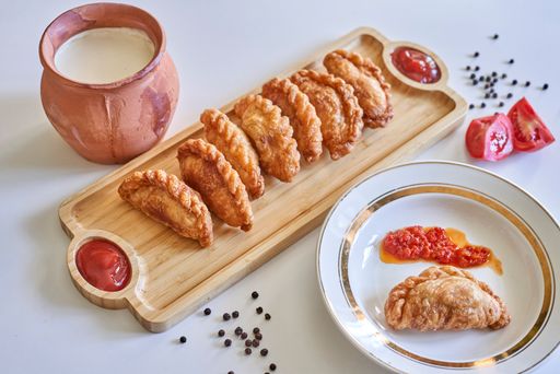 The homemade pies with tomato sauce on a wooden serving board