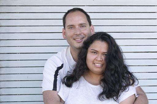 A Hispanic couple from Uruguay hugging and looking to the camera
