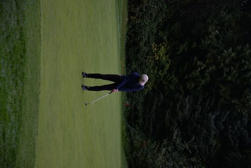 A golfer with a golf club taking a shot