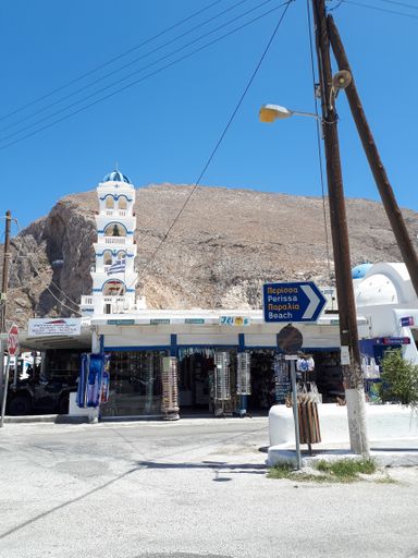 The White and blue dome and the bell tower of church in the background in Perissa city, Santorini island, Greece