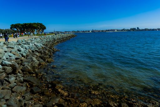 A daylight shot of a breakwater at seaside under clear blue sky