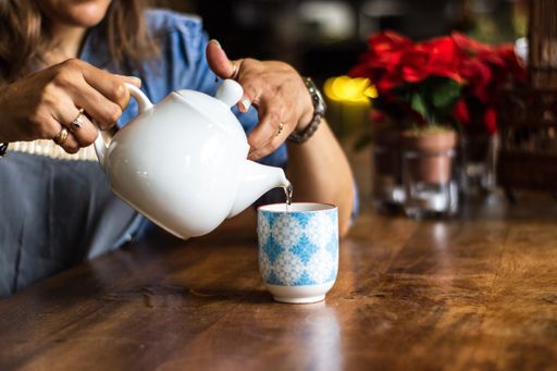 A close shot of female pouring water in a cup with a blurred background