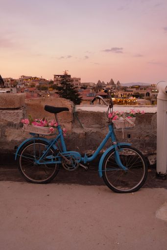 A vertical shot of an old blue bike on a roof in Cappadocia during sunset