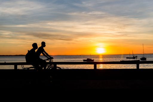 A beautiful silhouette of people walking and enjoying the sunset on Ribeira beach