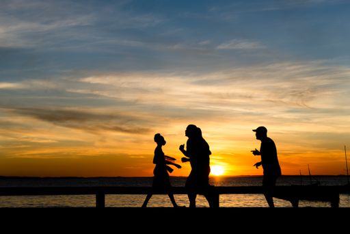 A Silhouette of people walking, running, talking and enjoying the sunset on Ribeira beach