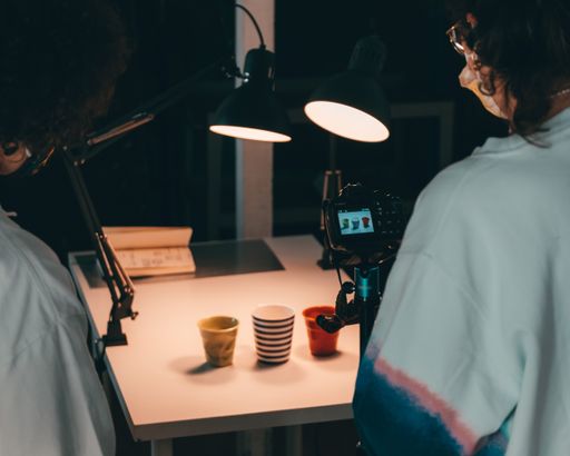 Two photographers taking a picture of cups