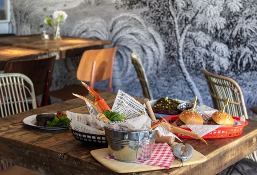 A close shot of different dishes on a wooden table with a blurred background