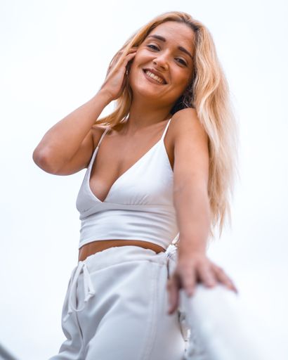 A vertical shot of a beautiful female wearing white on a stairway captured in San Sebastian, Spain