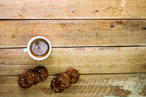 A top view of biscuits and a cup of coffee on a wooden board