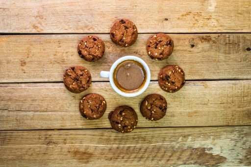 A top view of fresh biscuits and a coffee cup on a wooden table