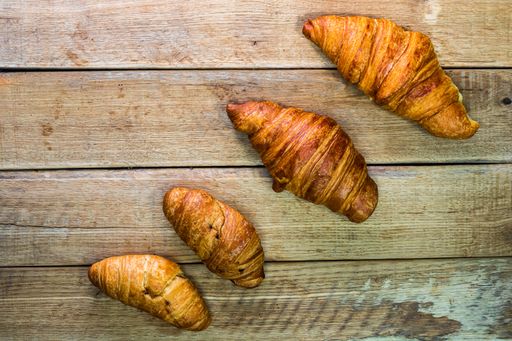 A top view of fresh croissants on a wooden table with copy space