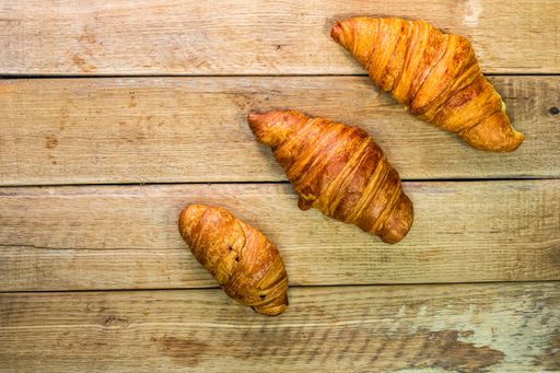 A top view shot of tasty croissants on a wooden table