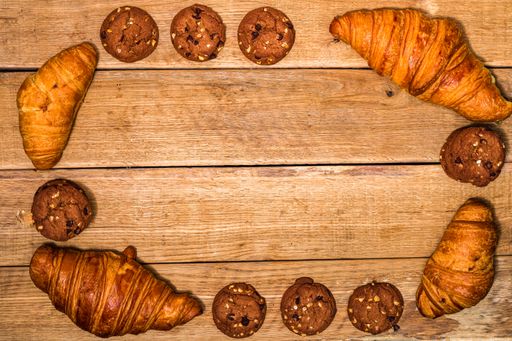 A top view of fresh biscuits and a coffee cup on a wooden table