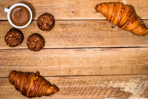 The fresh croissant and biscuits on wooden table. Coffee, food, and breakfast concept. Desserts, fresh pastries, and coffee. Top view and copy space
