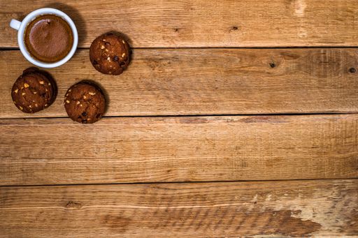A top view of fresh biscuits and a cup of coffee in the wooden background with a copy space