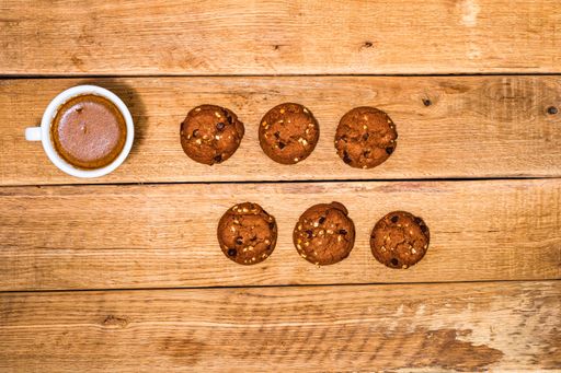 A top view of fresh biscuits and a coffee cup on a wooden table