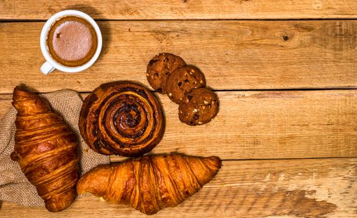 The fresh croissant and biscuits on wooden table. Coffee, food, and breakfast concept. Desserts, fresh pastries and coffee. Top view and copy space