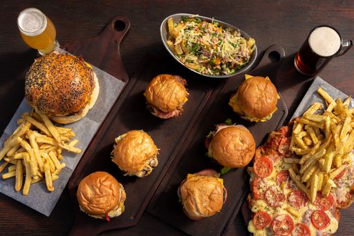A top view of delicious fast food with burgers, French fries, and bee on the wooden table