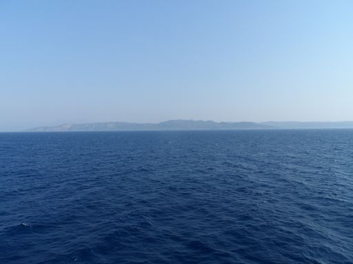 A beautiful scenery of calm sea and barely visible land on the background