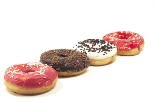 A closeup of American glazed doughnuts under the lights isolated on a white background