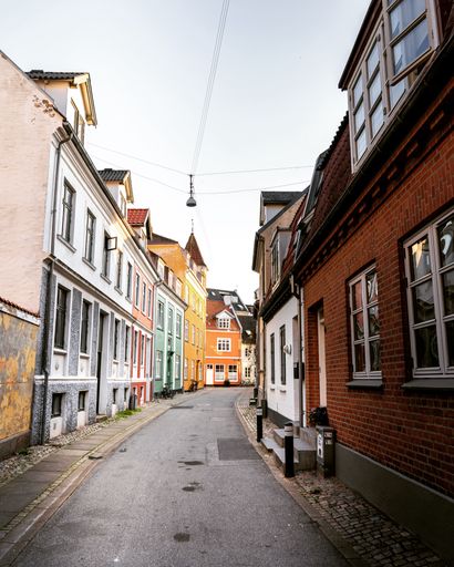 A vertical shot of a street surrounded by small buildings under the clear skies