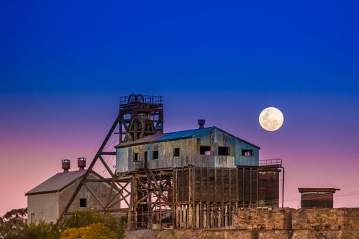 A beautiful view of the industrial buildings and full moon in the clear sky