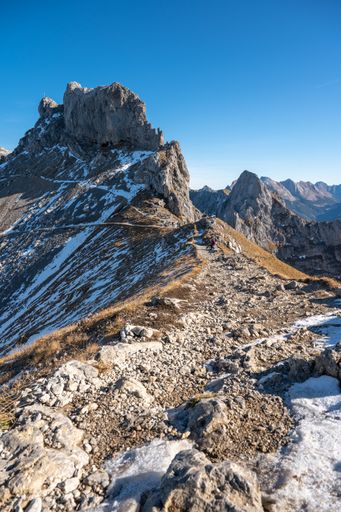 A beautiful scene of the rocky Karwendel snowy mountain with a light blue sky on a sunny day