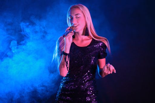 A young sexy blonde female singer holding a microphone