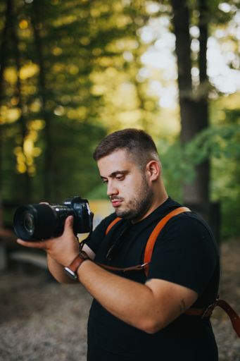 A shallow focus shot of a young Caucasian male with a professional camera