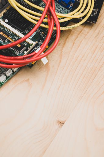 electronic devices integrated circuit boards and cables piled up on a wooden background with space for text