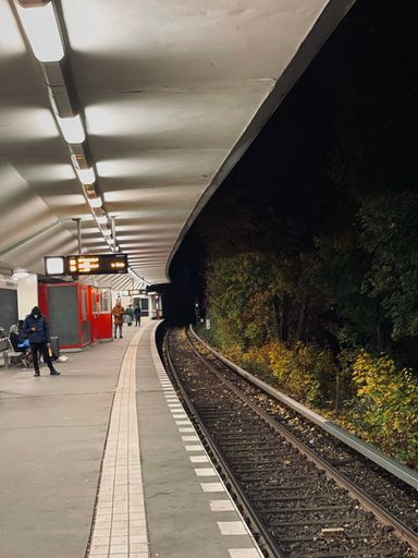 A vertical shot of an outdoor train station at night in Berlin, Germany