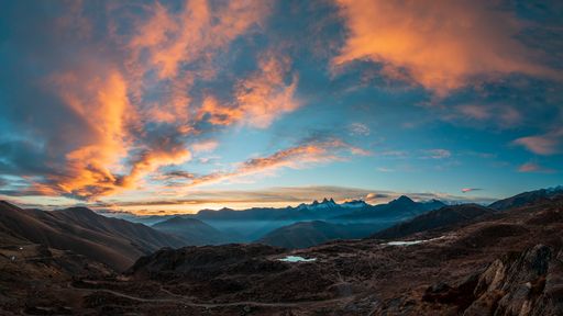 A scenic view of the Valley of Saint Sorlin and Aiguilles d'Arves mountain at sunrise, as seen from Col de la Croix de Fer in Savoie, France