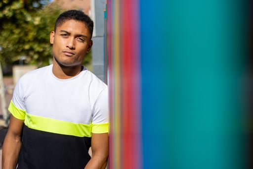 A shot of a Hispanic adult guy posing for a photoshoot in a colorful t-shirt.