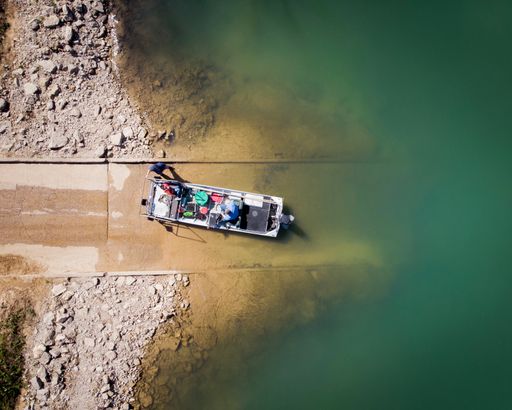 A beautiful top view shot of a small boat launching on the shore