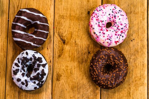 The glazed donuts with sprinkles on wooden table