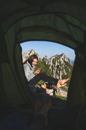 A beautiful young female hiker from Spain with her boyfrend in a tent on top of the mountain