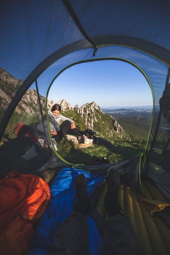 A beautiful young female hiker from Spain with her boyfirend in a tent on top of the mountain