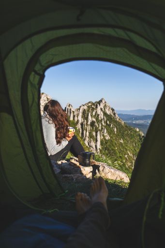 A beautiful young female hiker from Spain with her boyfirend in a tent on top of the mountain