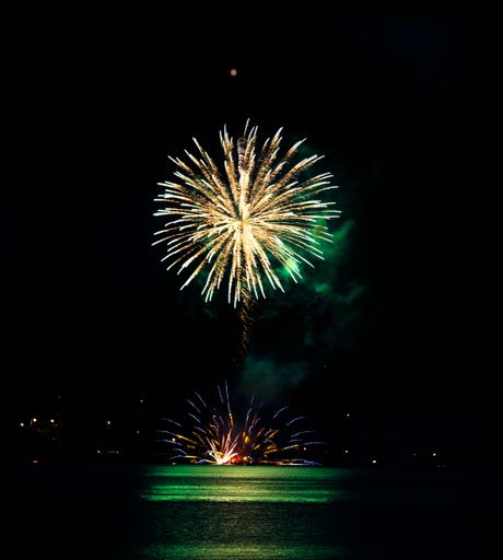 A vertical shot of big colorful fireworks in the night sky