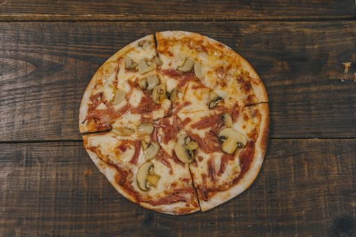 A top view of a homemade mushroom pizza on a wooden board